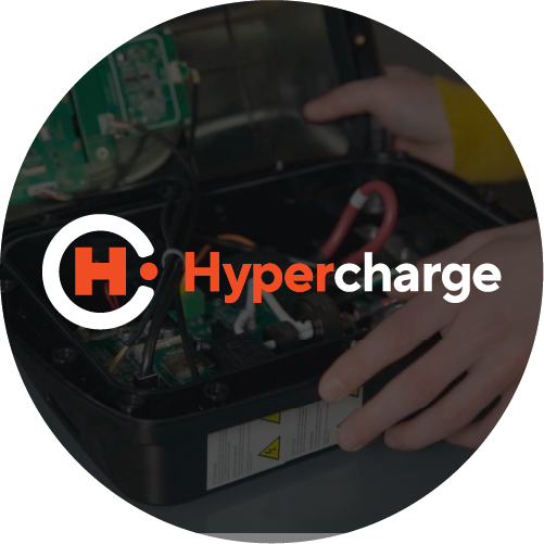 A person’s hands are working on the internal components of an electronic device. Overlaid is the Hypercharge logo, featuring a stylized “H” in a circle and the word Hypercharge in white and orange text.